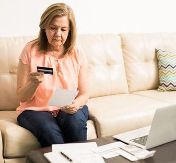 Beautiful,Serious,Retired,Latin,Woman,Analyzing,Her,Credit,Card,Statement MORE AMERICANS UNABLE TO PAY OFF CREDIT CARD BALANCES