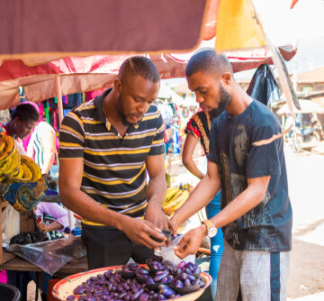 Young man buying pear in a local African market
