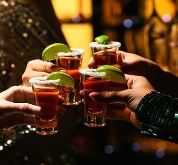 Hands with shots of tequila in a toast