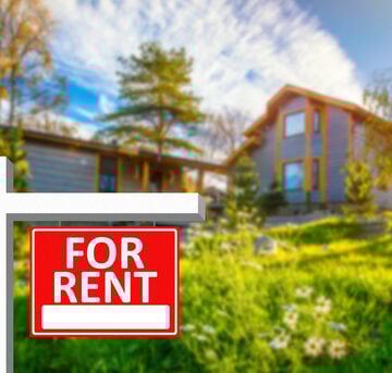 For Rent Sign Next to a Large House for Rent