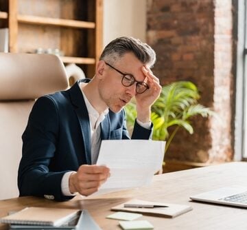 Distressed businessman looking over papers