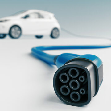 Close,Up,Of,Electric,Vehicle,Plug,Charging,Car,Isolated,On Close up of electric vehicle plug charging car