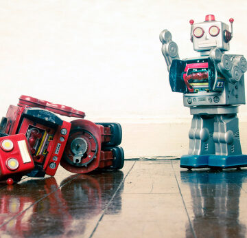 Robot,Wars,Red,Robot,Defeated,On,Old,Wooden,Floor Red Robot Standing and Blue Robot Knocked Over on Wooden Floor