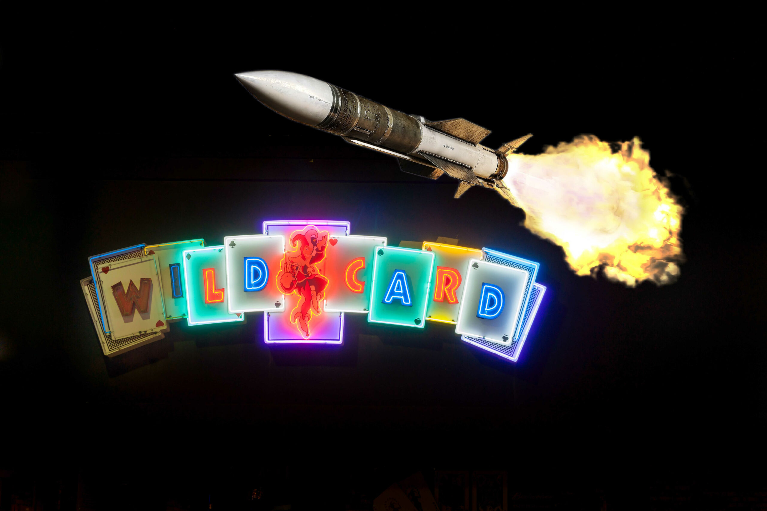 concept image of neon-lighted playing cards with rocket flying over.