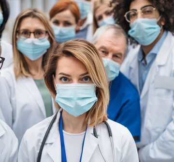 Group Of Doctors With Face Masks Looking At Camera