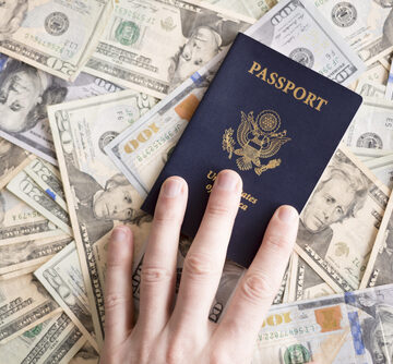 Hand,On,Passport,With,Money Hand On Passport With Money