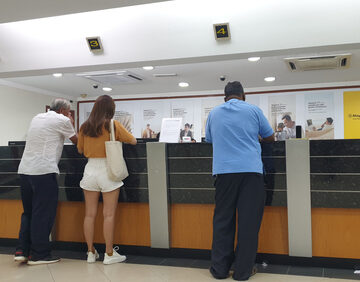 ECON-BANKS WILL STRUGGLE FOR YEARS Customers Standing At Bank Counter