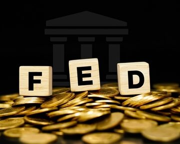 The Federal Reserve (FED) on Blocks Sitting Atop a Pile of Coins