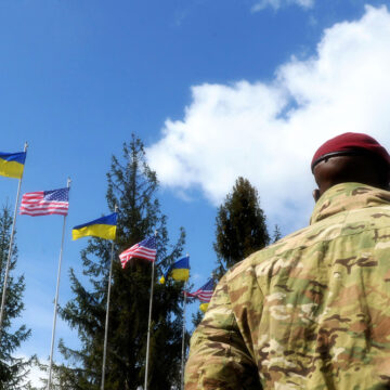 Back View of American Soldiers Standing Next To The U.S. And Ukraine Flags