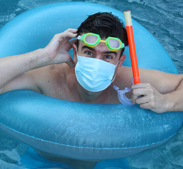 Man In The Pool With Surgical Mask, Snorkel, And Goggles