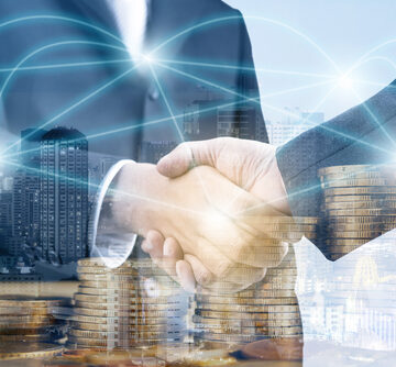 Double,Exposure,Of,Handshake,And,City,Night,With,Stack,Of Double-Exposure Of Handshake And City At Night