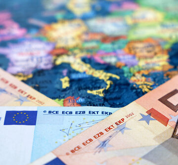 Euro,Banknotes,On,The,Europe,Map.,Concept,Of,Eurozone,,European Euro Banknotes On Top Of The Map Of Europe