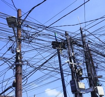 Messy Cable And Phone Wires Disorganized Above head On Telephone Poles