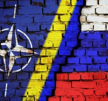 Nato, Ukraine And Russian Flags Spray-Painted in Brick Wall