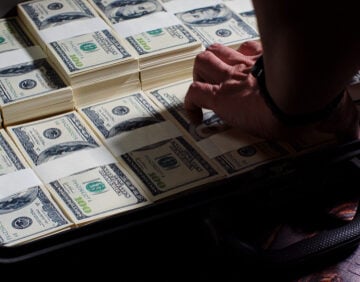 Man Packing $100 U.S. Bills Into Briefcase