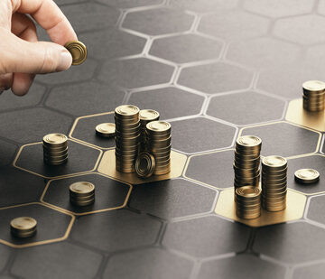 Hand Stacking Coins Over A Black Background With Hexagonal Inlay