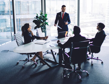 Corporate Boss Explaining Information During Conference Room Meeting With Staff