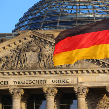 The German Flag In Front Of The Reichstag Building In Berlin