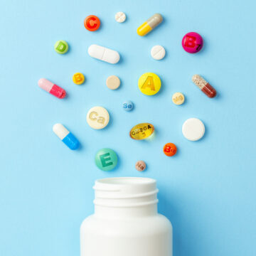 An Array Of Colorful Pills And Vitamins, And A Pill Bottle