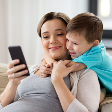 Pregnant Mother And Son Looking At Cellphone