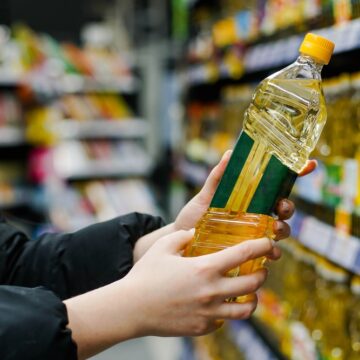 Woman Choosing Sunflower Oil In The Supermarket