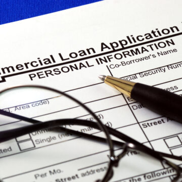 Commercial Loan Application Form With Eyeglasses and Pen