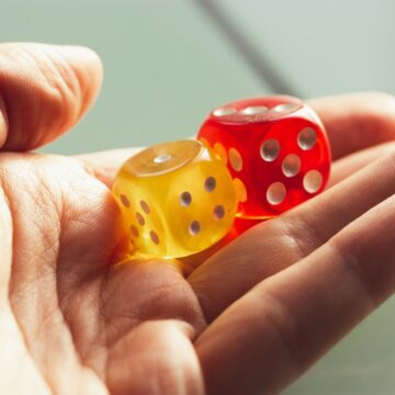 A Hand Getting Ready To Roll A PAir Of Dice