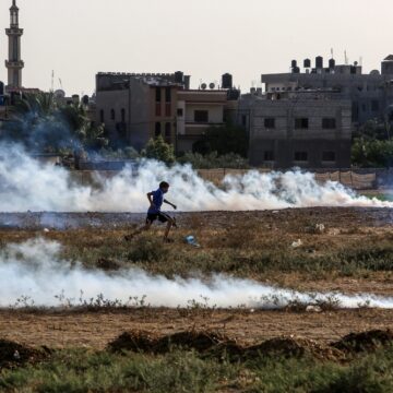 A Child Running Through A Field Of Smoke Flares Near The Palestinian Border