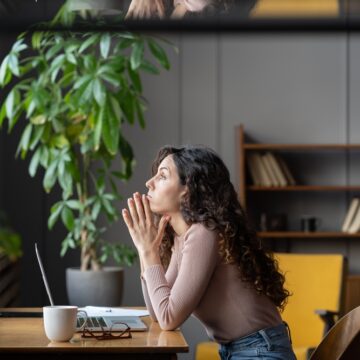 Bored Female Worker Sitting At Desk With Laptop