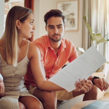 Stressed Young Couple Looking Over Bills