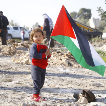 A Child Holds A Palestinian Flag In The Palestinian City Of Qalqilya