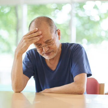 Despairing Older Man With Head In Hand