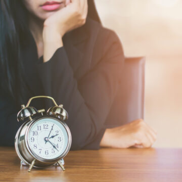 Woman Patiently Waiting By An Alarm Clock