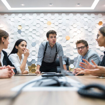 Young Businesspeople Meeting Around A Conference Table In Office