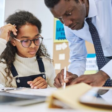 Portrait,Of,Male,Teacher,Helping,Young,African,American,Schoolgirl,Struggling Male Teacher Helping Young Schoolgirl With Her Classwork