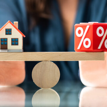 Cube With Percentage Sign Balancing With Houses On Other End