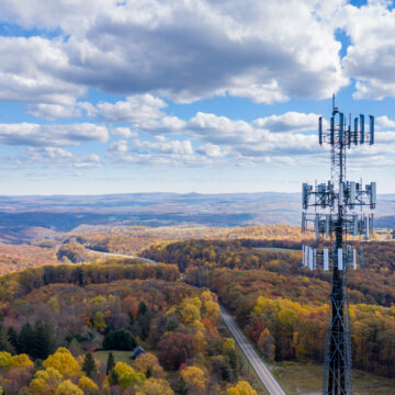Aerial,View,Of,Mobiel,Phone,Cell,Tower,Over,Forested,Rural MAN SUES WIRELESS PROVIDERS FOR CAUSING SEVERE ILLNESS