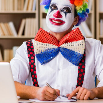 Happy Clown Sitting At A Desk Writing In A Notebook