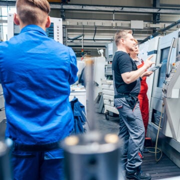 German Factory Workers Inspecting Equipment