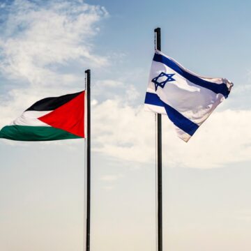 The Israel And Palestinian Flags Next To Each Other On Flagpoles