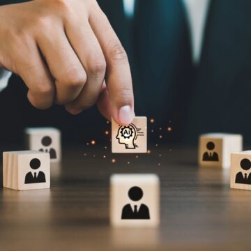 Businessman,Picked,Up,A,Wooden,Block,With,An,Ai,Icon, AI WILL CUT CORPORATE WORKFORCE 5 PERCENT THIS YEAR, BOSSES SAY