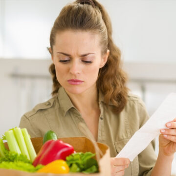 Dismayed Housewife Examines Receipt After Grocery Shopping