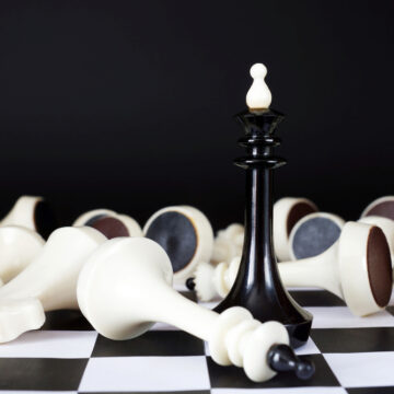 Chess King Among Defeated Enemies Pieces On Chess Board