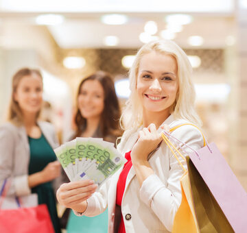 Happy Young Women Shopping With A Handful Of Euros