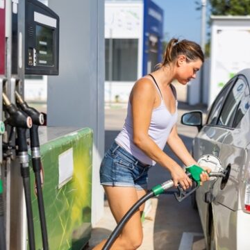 Woman Filling Up Tank Of Her Car With Gasoline
