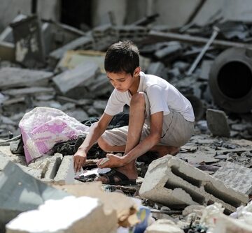 Palestinian Child Sorting Through The Rubble In Gaza
