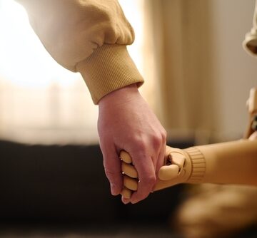 Little Girl With Partial Arm Prosthesis Holding Her Mother By The Hand