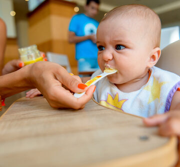 Mom,Feeds,The,Baby,From,A,Spoon.,Mom,Gives,The Mom Feeds Baby A Spoonful Of Applesauce