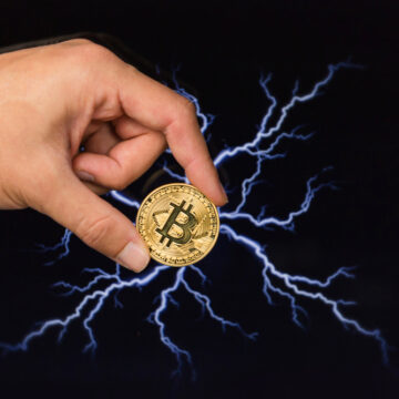 Man,Holding,Bitcoin,Gold,Coin,In,Front,Of,Lightning,Network COINBASE PARTNERING WITH LIGHTSPARK TO LOWER BITCOIN TRANSACTION FEES