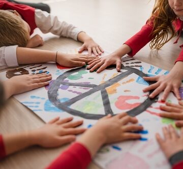 School Children Making A Poster Of A Peace Sign